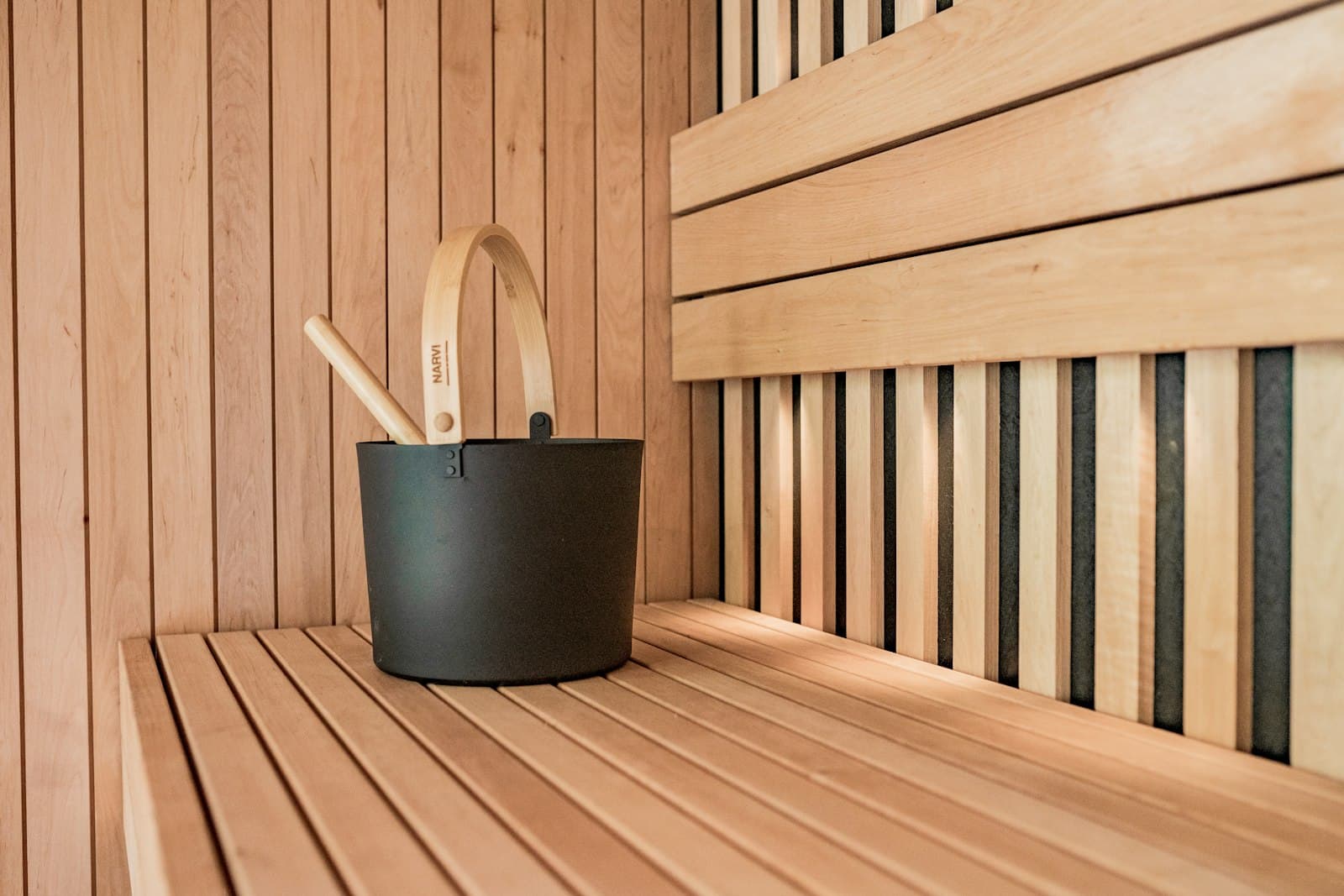 Sauna bucket and ladle detail on a wooden bench